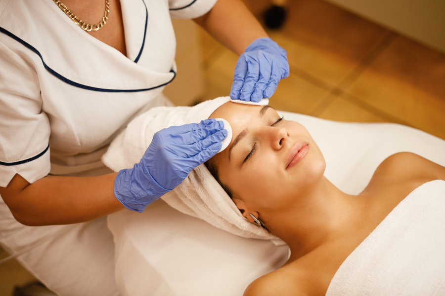Above view of young woman during beauty treatment at the salon. High angle view of beautiful woman having beauty treatment at the spa.