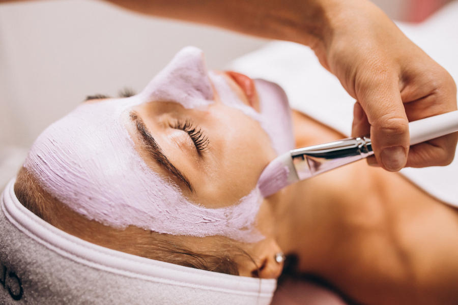 Above view of young woman during beauty treatment at the salon. High angle view of beautiful woman having beauty treatment at the spa.